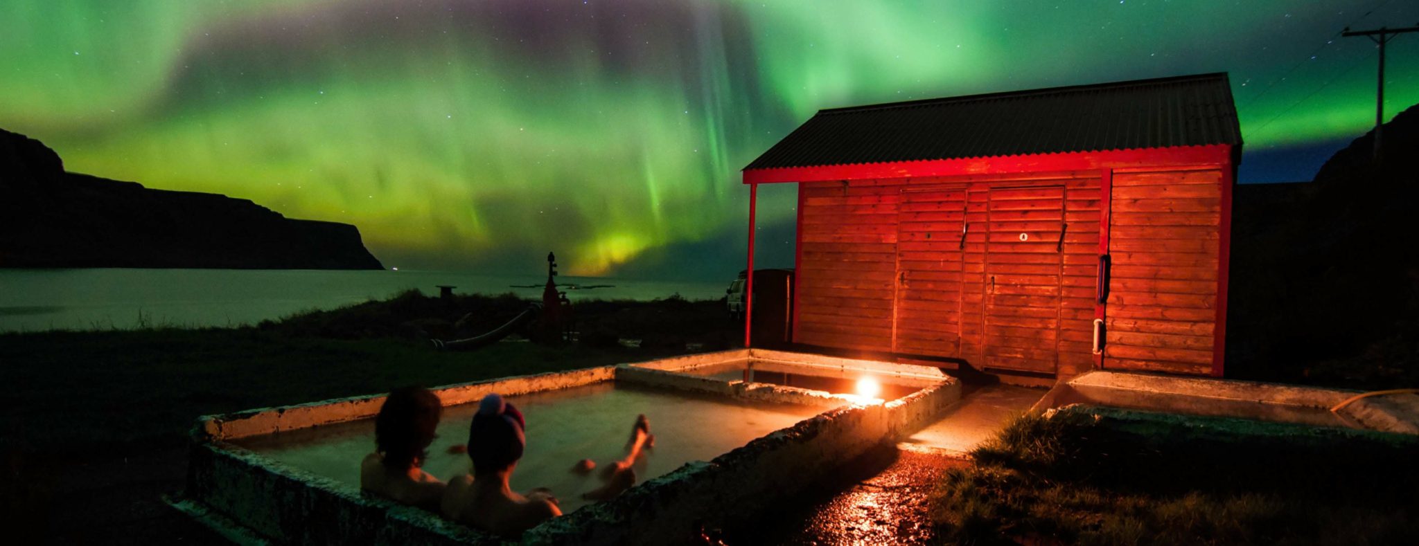 Noorderlicht op IJsland vanuit geothermisch verwarmd badje